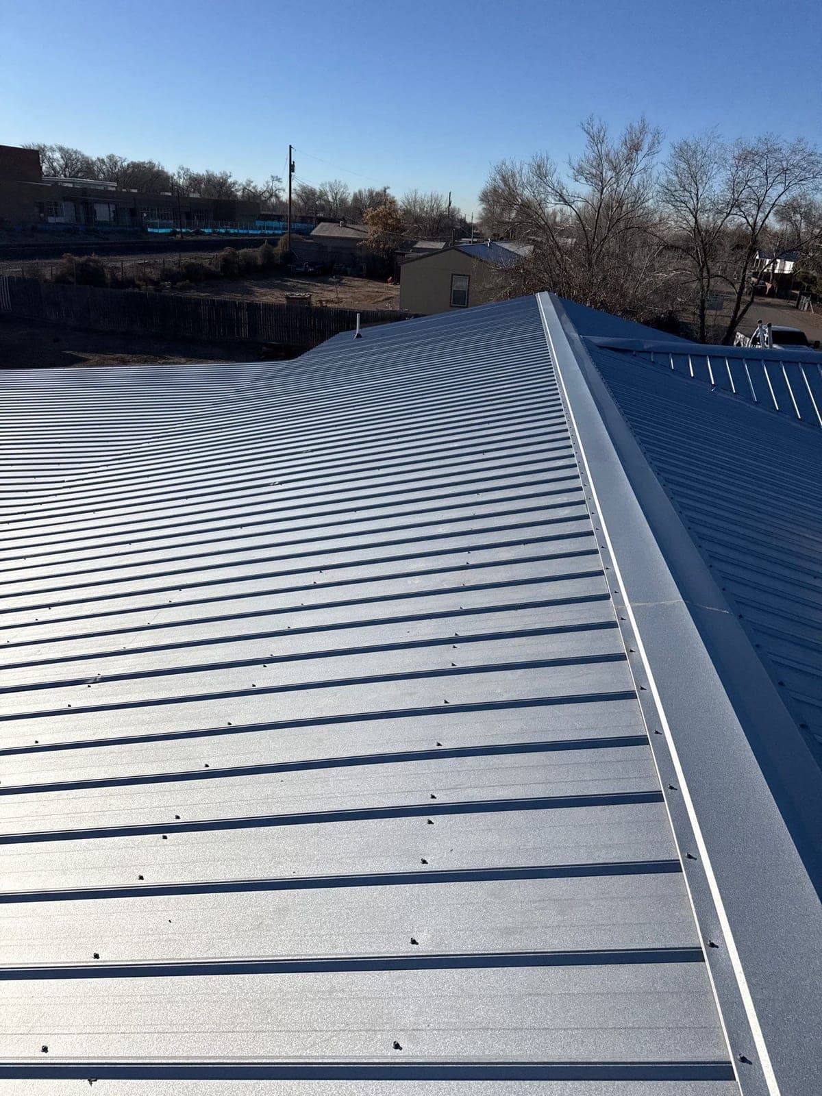 A finished gray R-panel metal roof on a New Mexico home by Paramount Roofing