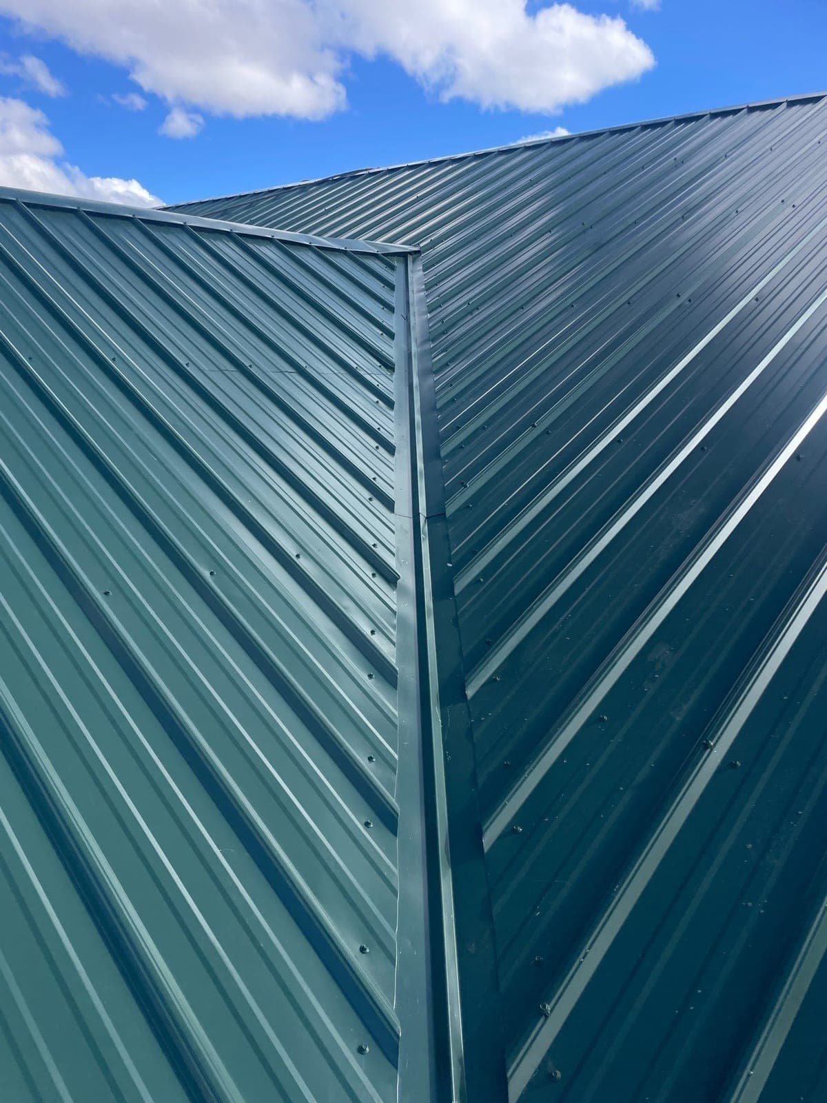 A finished green R-panel metal roof on a New Mexico home by Paramount Roofing