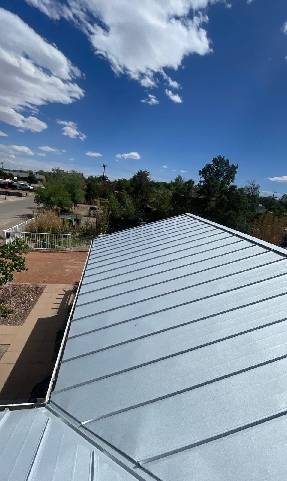 A completed silver standing-seam metal roof on a New Mexico home by Paramount Roofing