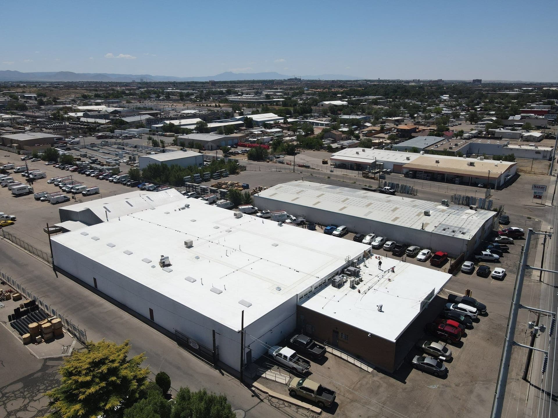 Aerial view of finished white TPO roofs across a New Mexico commercial warehouse complex by Paramount Roofing