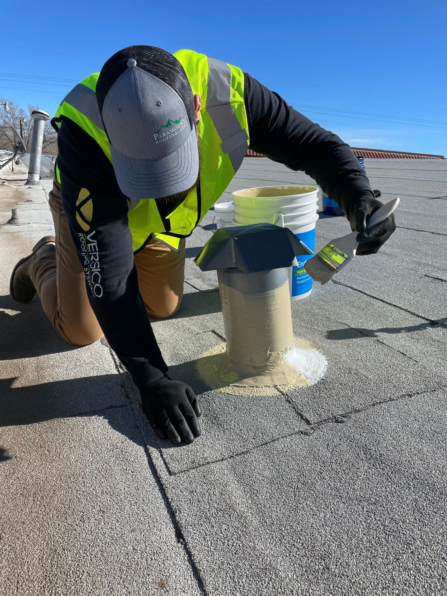 A Paramount Roofing technician sealing a roof penetration on a flat commercial roof in New Mexico